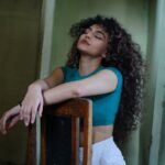 woman with curly hair posing on a chair