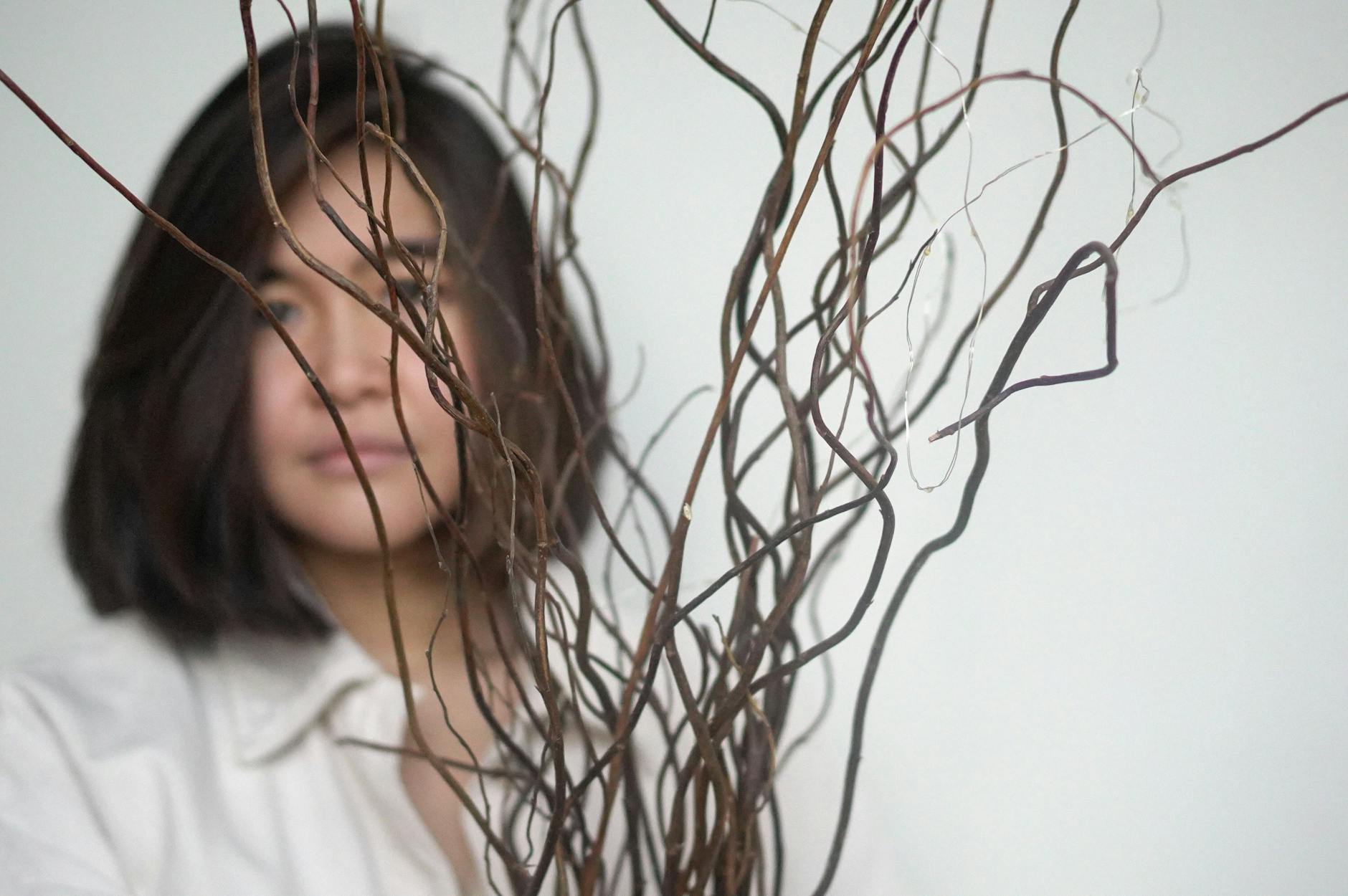 asian woman near dry decorative branches